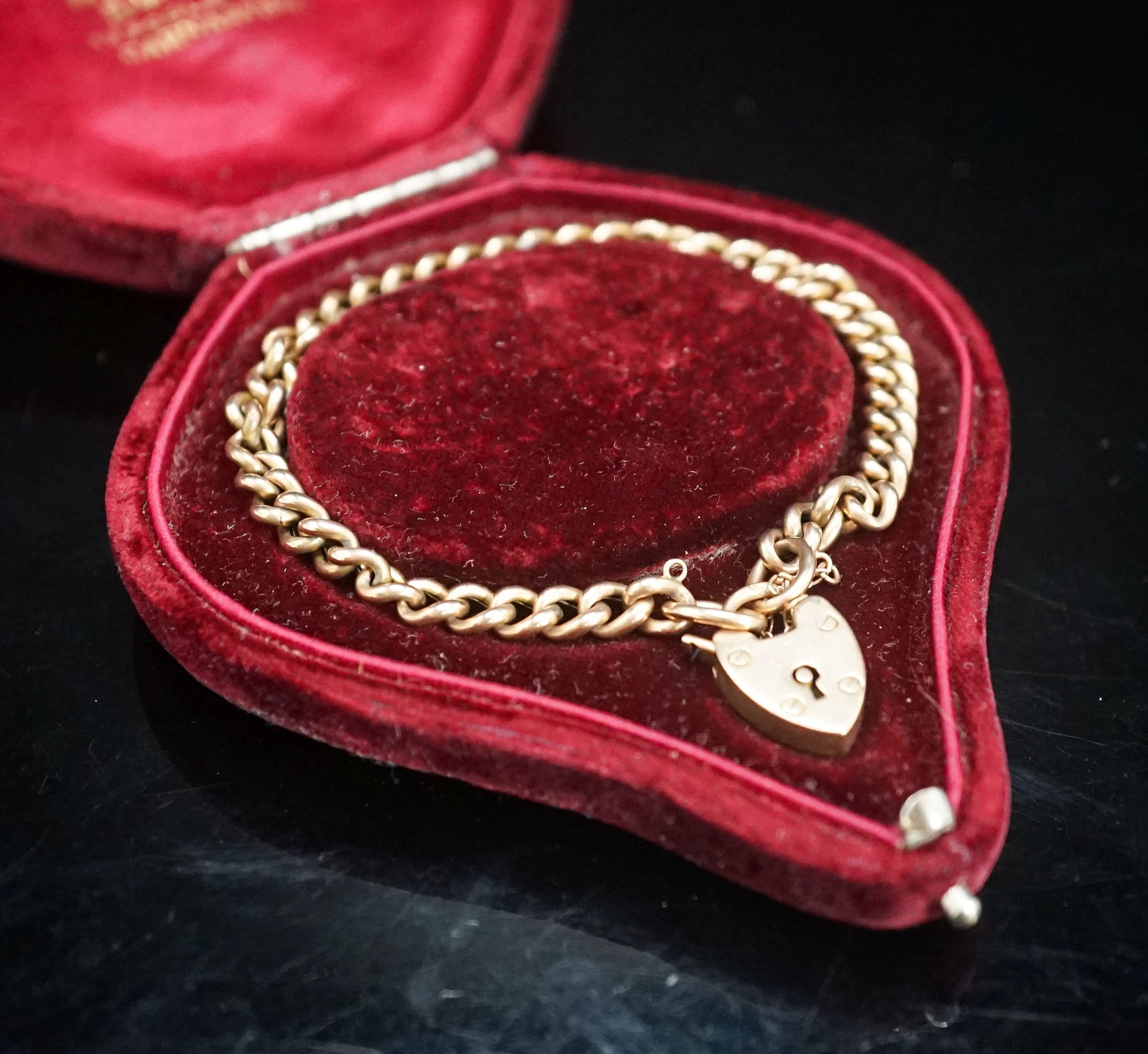 A 9ct gold curb link bracelet with heart shaped clasp (no key), 20cm, 10 grams.